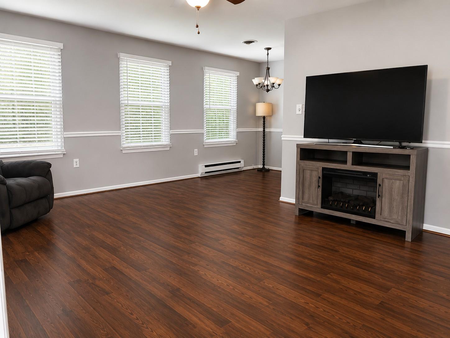 7006 Basswood Road Frederick, MD 21703 - Photo 2 of 10 an empty room with windows flat screen tv and fireplace