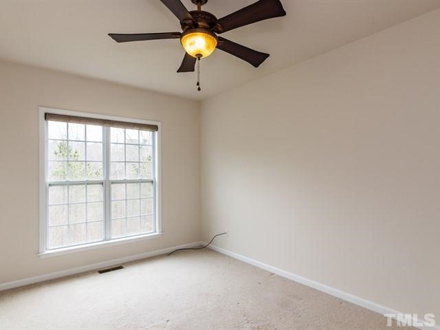 209 Amiable Loop Cary, NC 27519 - Photo 12 of 25 an empty room with a window and a ceiling fan