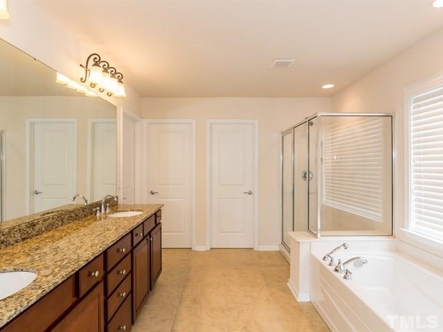 209 Amiable Loop Cary, NC 27519 - Photo 16 of 25 a bathroom with a granite countertop sink and a bathtub
