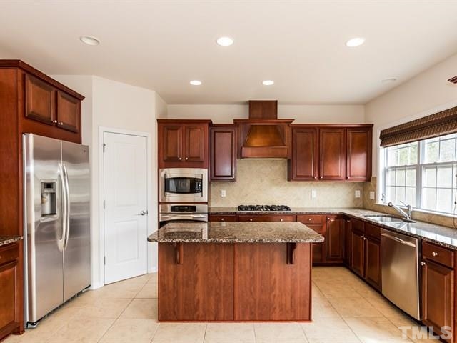 209 Amiable Loop Cary, NC 27519 - Photo 9 of 25 a kitchen with stainless steel appliances granite countertop a stove a sink dishwasher a refrigerator and a microwave oven with cabinets