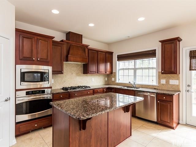 209 Amiable Loop Cary, NC 27519 - Photo 10 of 25 a kitchen with granite countertop a stove sink and microwave