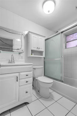 a bathroom with a granite countertop toilet sink and mirror