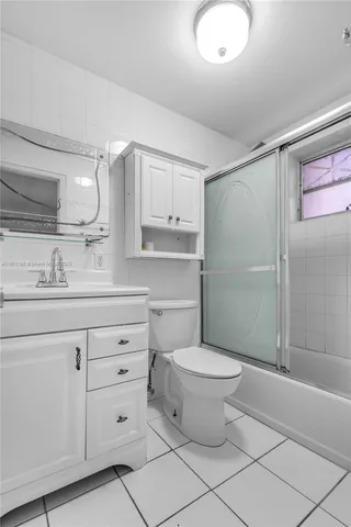 a bathroom with a granite countertop toilet sink and mirror