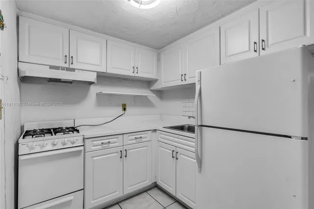 a kitchen with white cabinets and white appliances