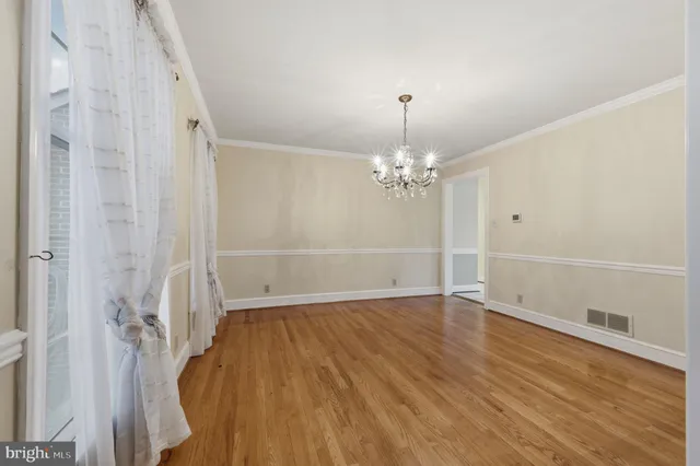 a view of a room with wooden floor and ceiling fan