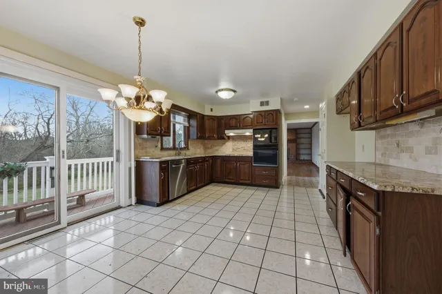 a large kitchen with granite countertop a sink and cabinets