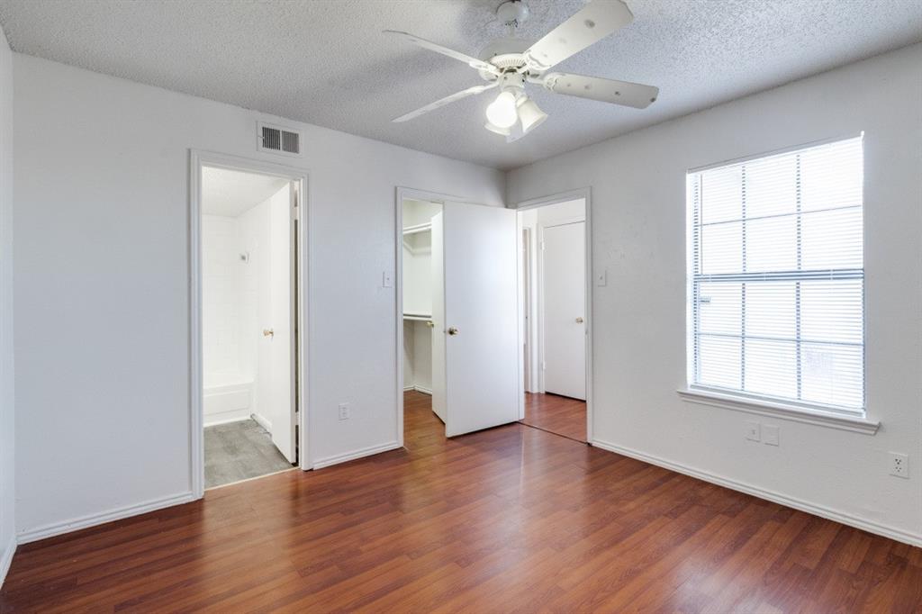 11311 Audelia Road, Unit 239 Dallas, TX 75243 - Photo 4 of 12 an empty room with wooden floor ceiling fan and windows