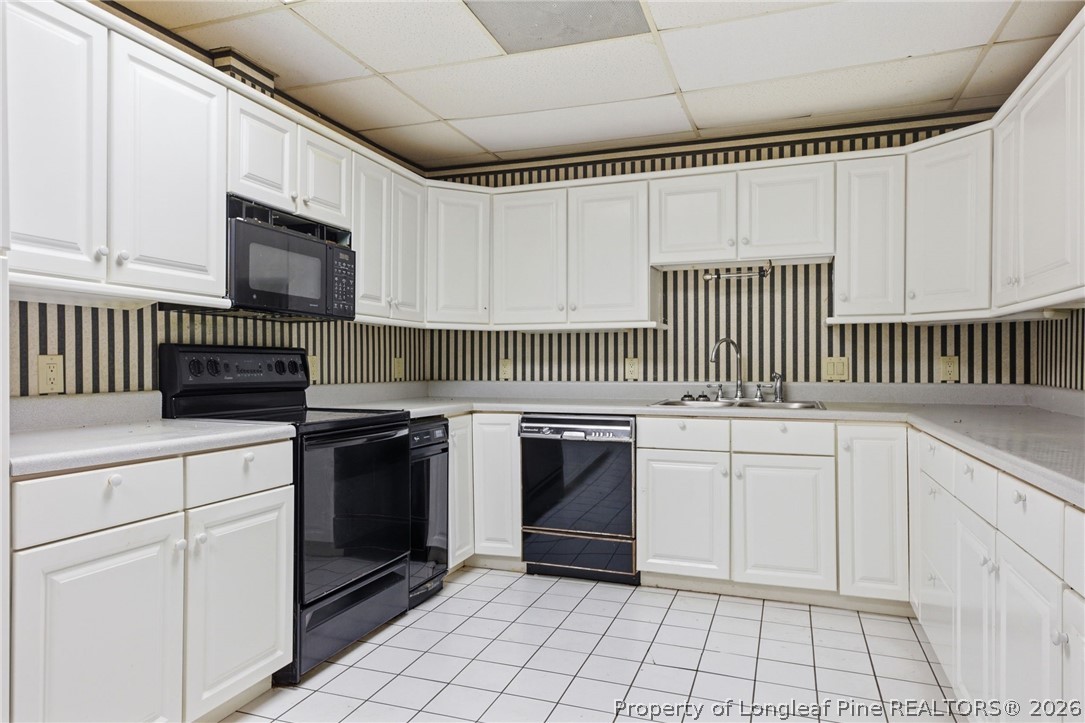478 Rattlesnake Trail Aberdeen, NC 28315 - Photo 23 of 44 a kitchen with white cabinets a sink and appliances