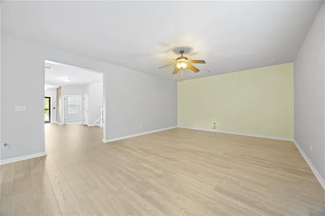 a view of empty room with wooden floor and table and chair