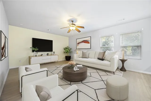 a living room with furniture a flat screen tv and a window