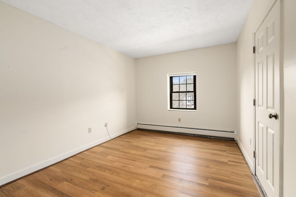 16 Winter Street, Unit 41C Waltham, MA 02451 - Photo 12 of 25 an empty room with wooden floor and windows