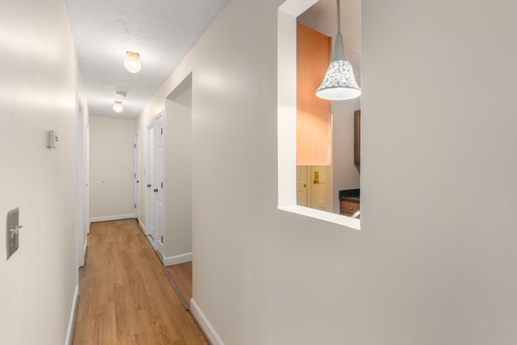 16 Winter Street, Unit 41C Waltham, MA 02451 - Photo 15 of 25 a view of a hallway with wooden floor and a chandelier
