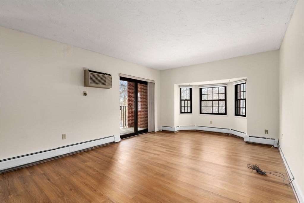 16 Winter Street, Unit 41C Waltham, MA 02451 - Photo 9 of 25 an empty room with wooden floor and windows