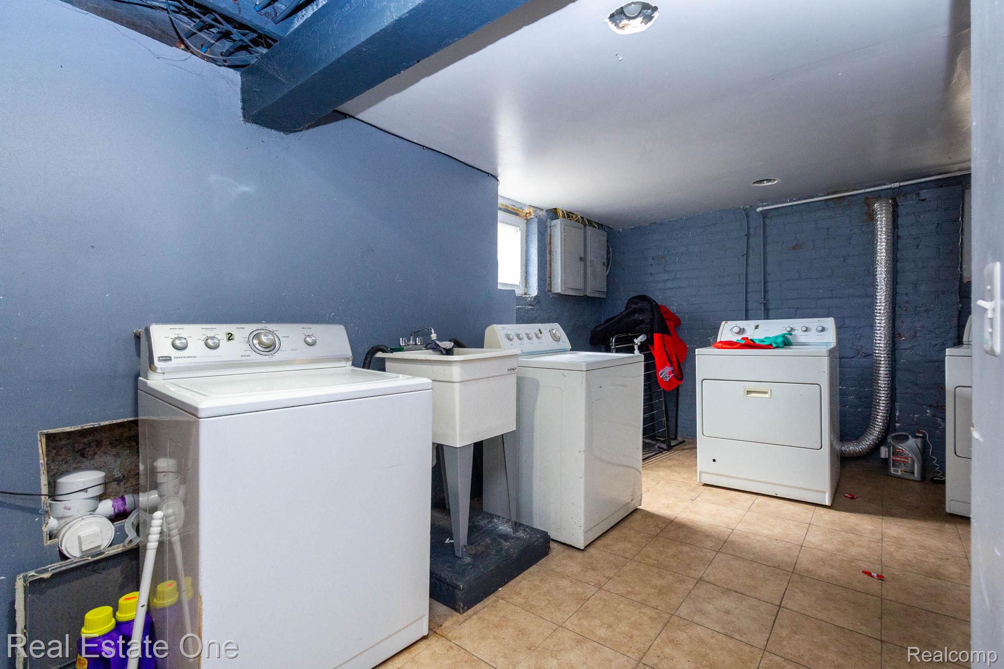 5485 Springwells Street Detroit, MI 48210 - Photo 43 of 47 Utility room featuring tiled flooring, a utility sink, and painted brick walls