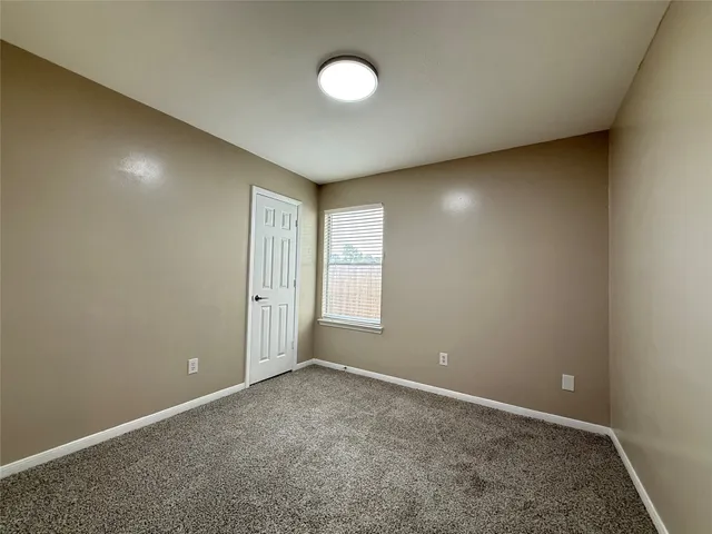 an empty room with a window and closet