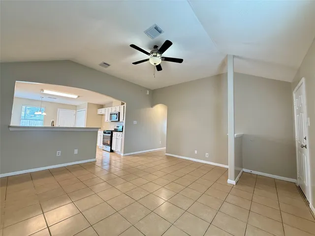 a view of an empty room and window and a ceiling fan
