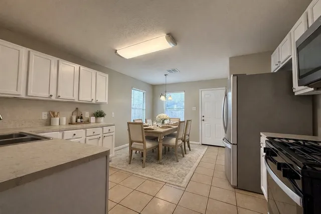 a kitchen with stainless steel appliances granite countertop a refrigerator and a stove top oven