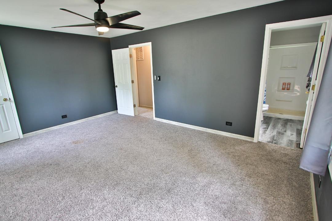 1189 Cumberland Road Aurora, IL 60504 - Photo 12 of 23 an empty room with a mirror and a ceiling fan