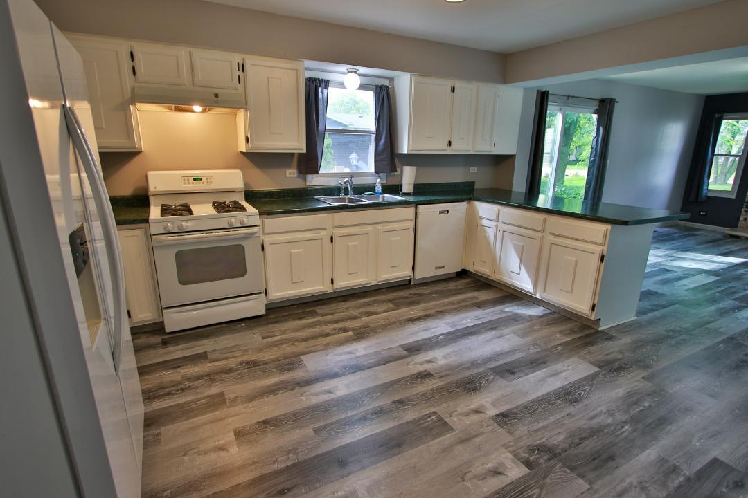 1189 Cumberland Road Aurora, IL 60504 - Photo 4 of 23 a kitchen with granite countertop white cabinets and white appliances