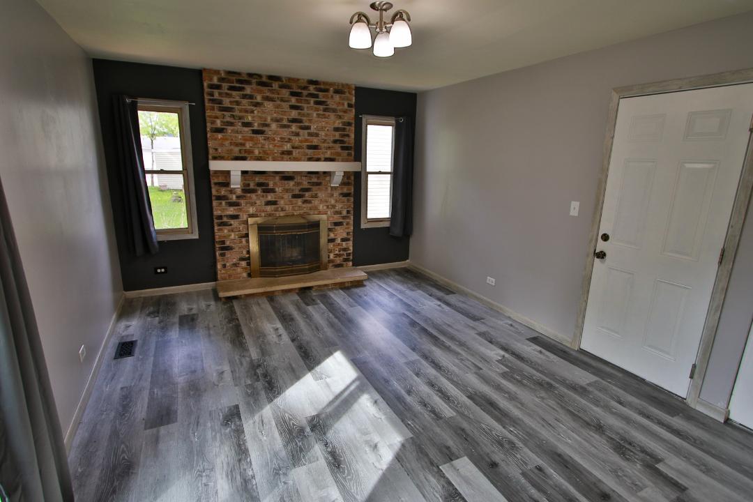 1189 Cumberland Road Aurora, IL 60504 - Photo 5 of 23 wooden floor in an empty room with a fireplace