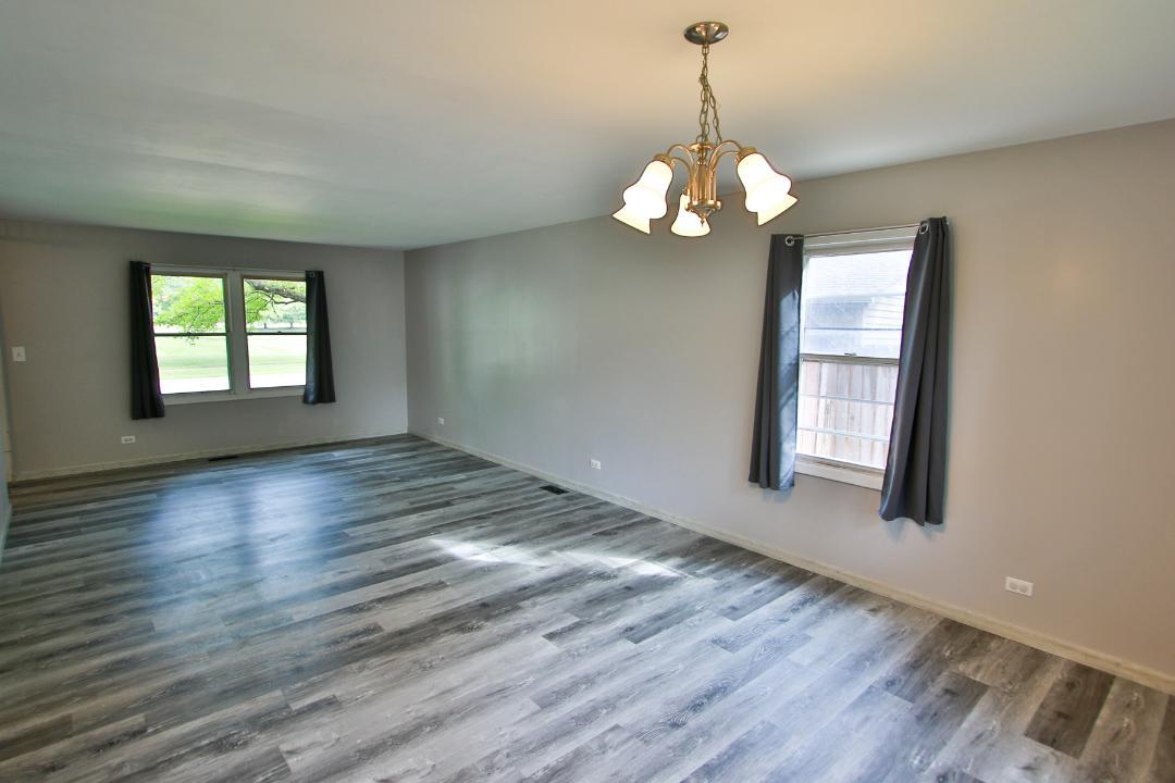 1189 Cumberland Road Aurora, IL 60504 - Photo 8 of 23 a view of an empty room with wooden floor and a window