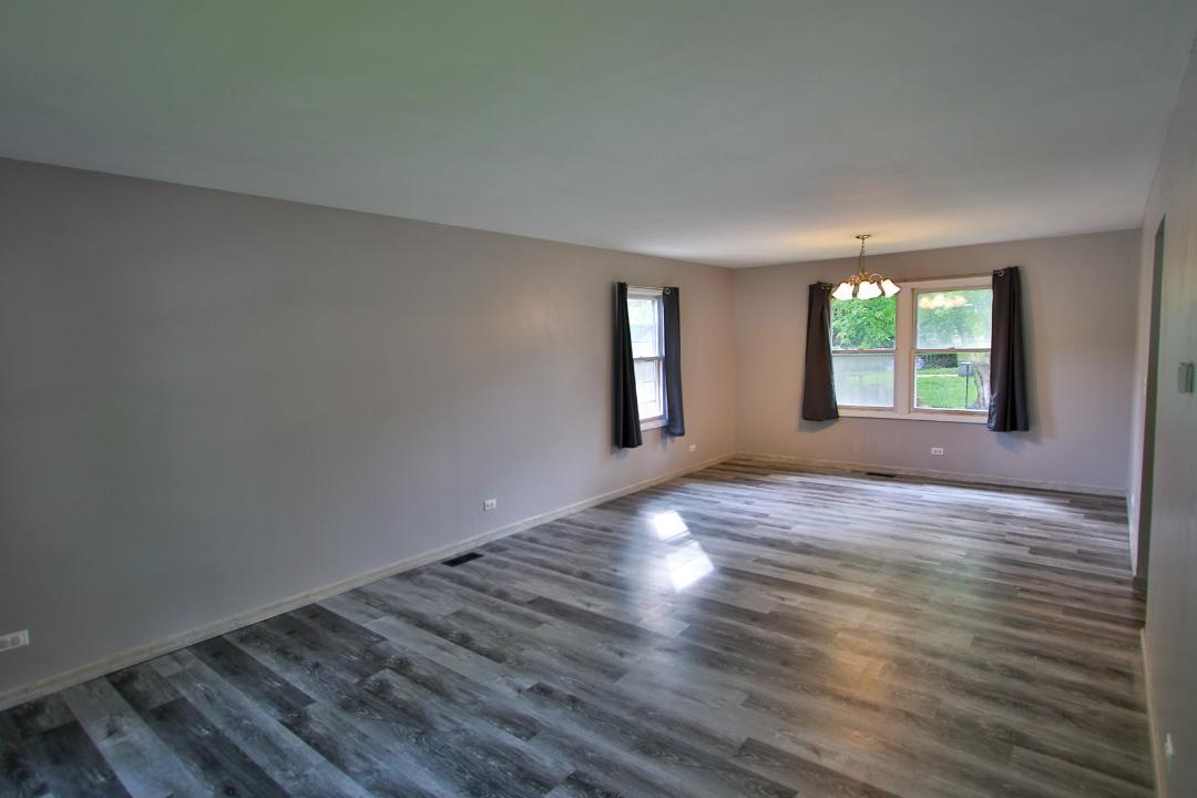 1189 Cumberland Road Aurora, IL 60504 - Photo 9 of 23 a view of an empty room with wooden floor and windows