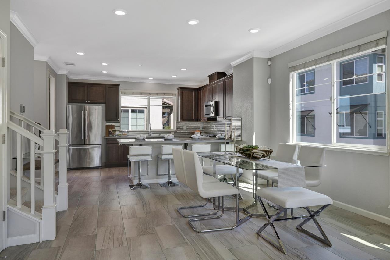 3079 Manuel Loop San Jose, CA 95136 - Photo 12 of 64 a kitchen with stainless steel appliances kitchen island granite countertop a dining table chairs refrigerator and sink