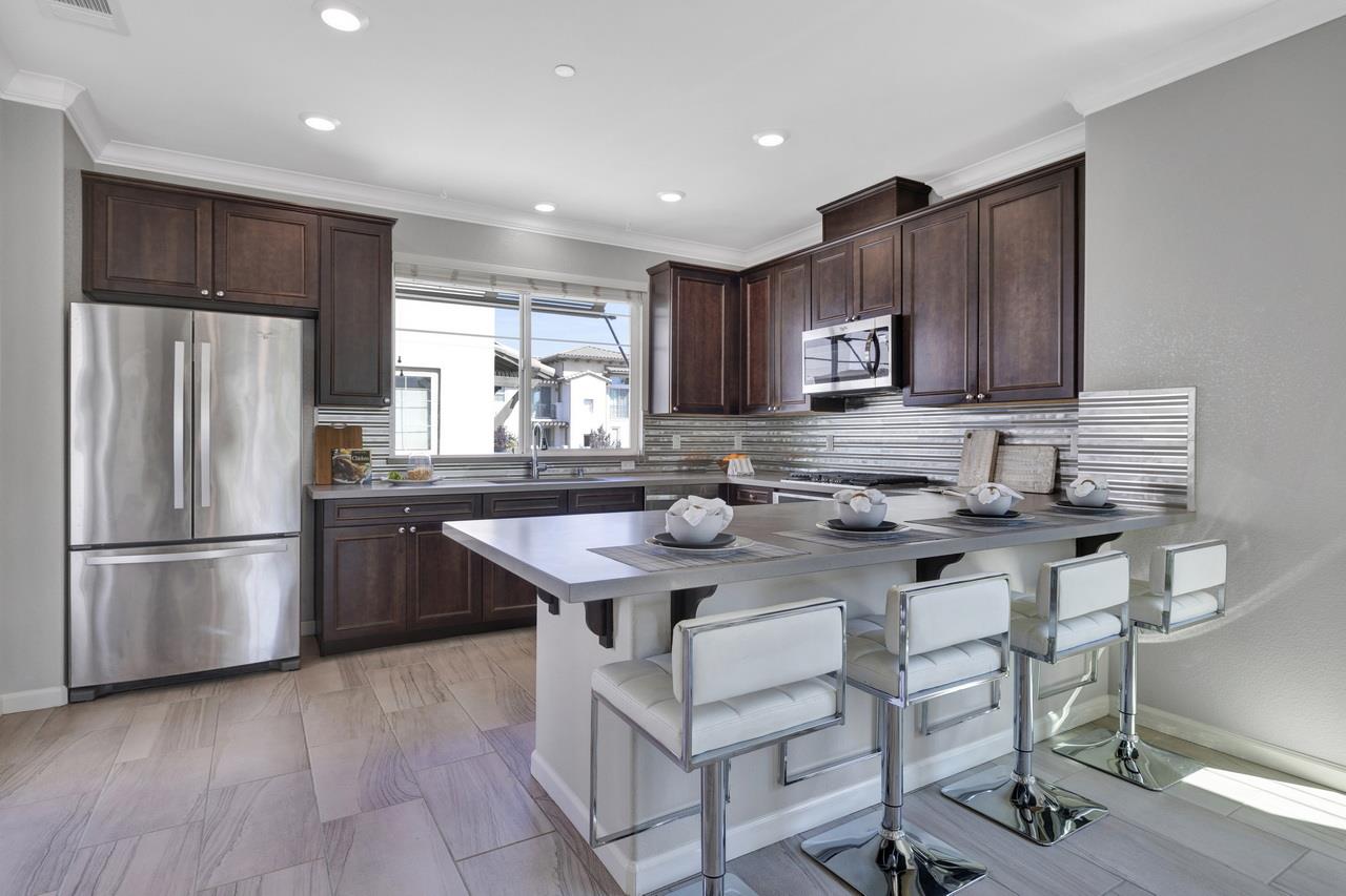 3079 Manuel Loop San Jose, CA 95136 - Photo 15 of 64 a kitchen with stainless steel appliances granite countertop a refrigerator a sink a stove a microwave and wooden cabinets