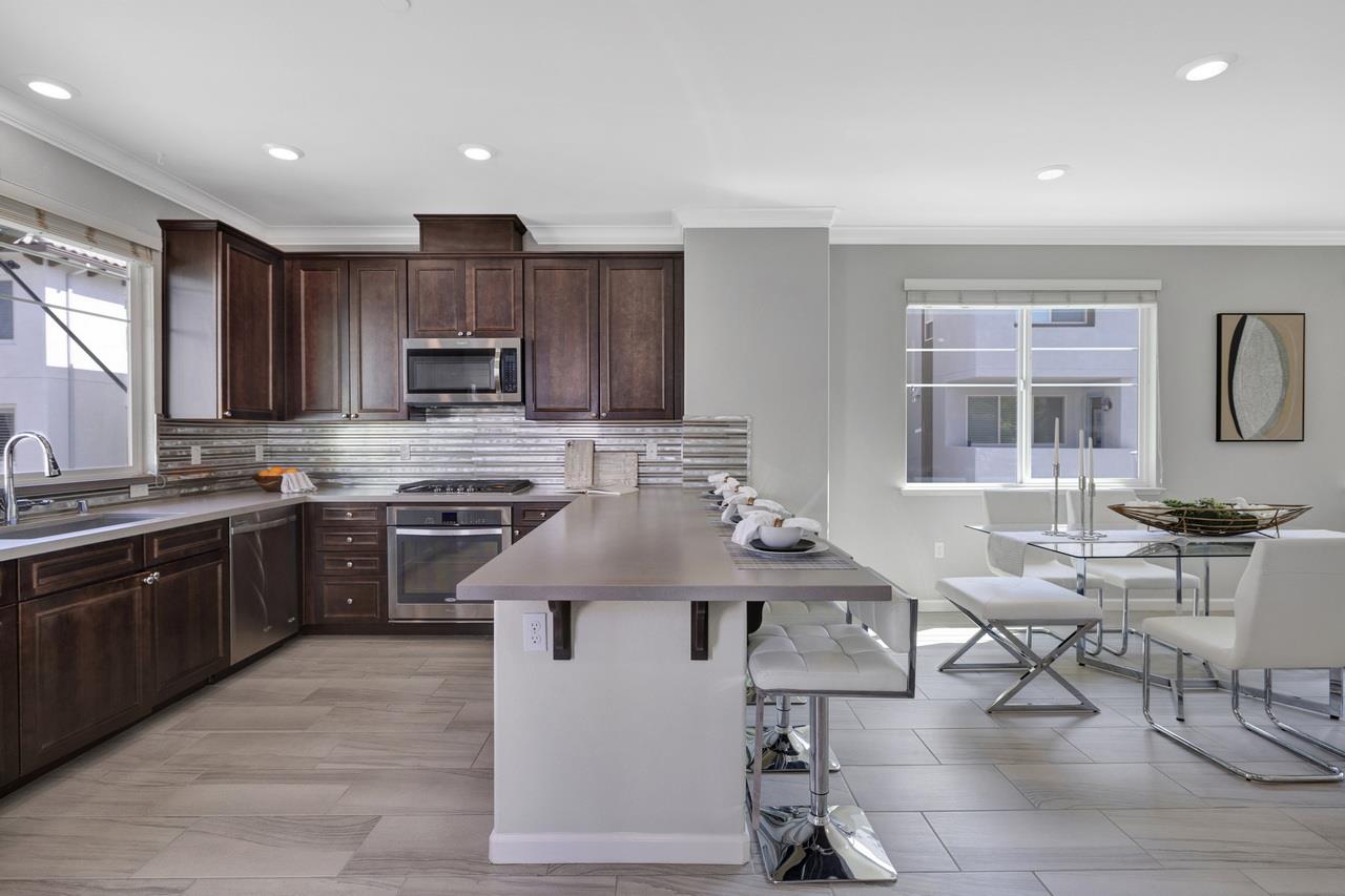 3079 Manuel Loop San Jose, CA 95136 - Photo 19 of 64 a kitchen with stainless steel appliances granite countertop a stove top oven a sink dishwasher a dining table and chairs with wooden floor