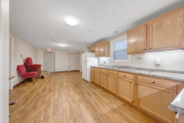 a large kitchen with stainless steel appliances granite countertop a stove and a wooden floors