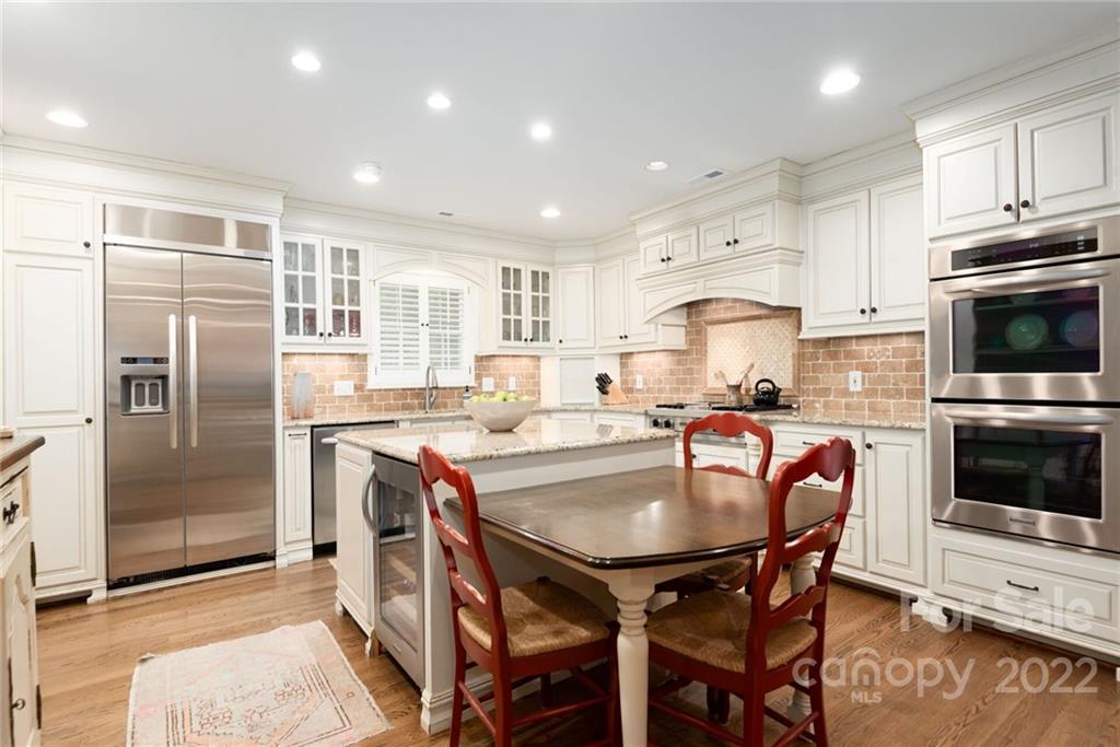 2815 Wickersham Road Charlotte, NC 28211 - Photo 10 of 34 a kitchen with stainless steel appliances granite countertop a stove a refrigerator a sink a dining table and chairs