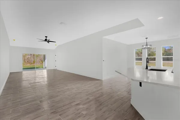 a view of a livingroom with wooden floor and a ceiling fan