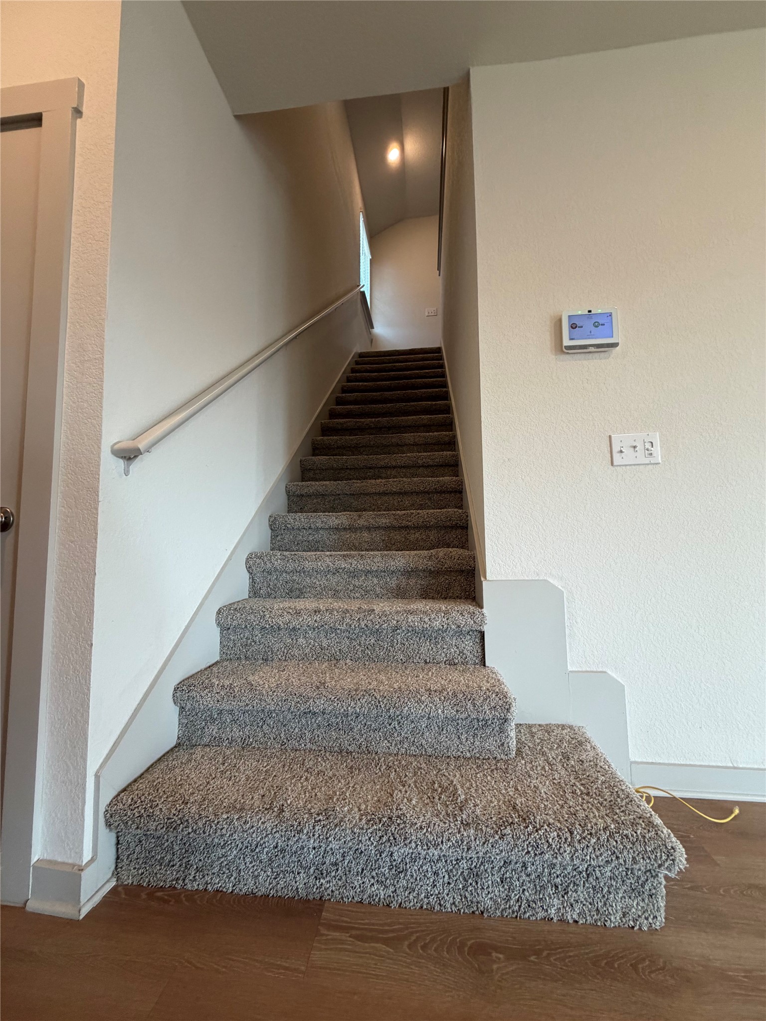 10708 Gonzales Ranger Pass Austin, TX 78754 - Photo 16 of 40 Carpeted staircase ascends from rich hardwood floors, providing a cozy transition between levels.