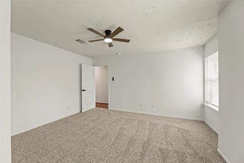 an empty room with closet and a ceiling fan