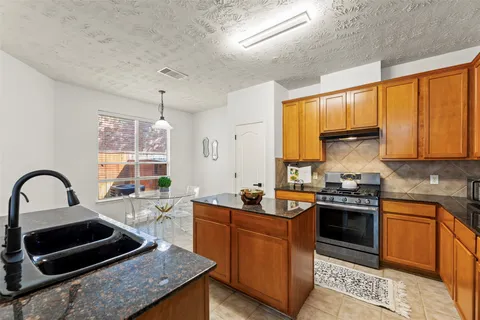 a kitchen with stainless steel appliances granite countertop a stove a sink and a microwave