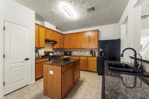 a kitchen with stainless steel appliances granite countertop a stove a sink dishwasher and a refrigerator