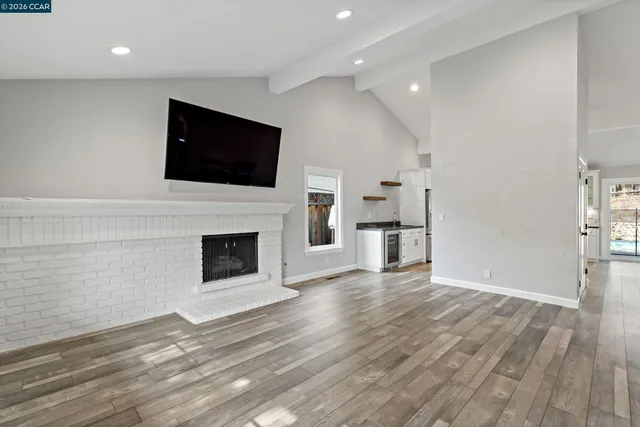 a view of a livingroom with a fireplace a flat screen tv and staircase