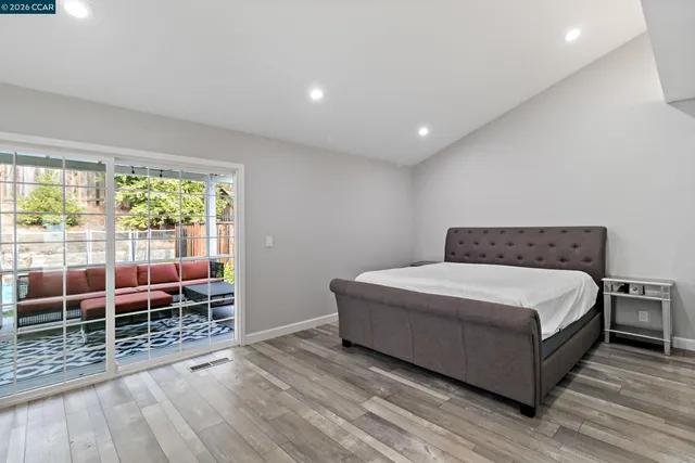 a room with a bed and wooden floor