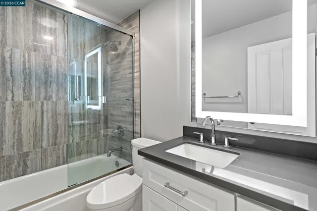 a bathroom with a granite countertop sink toilet and shower