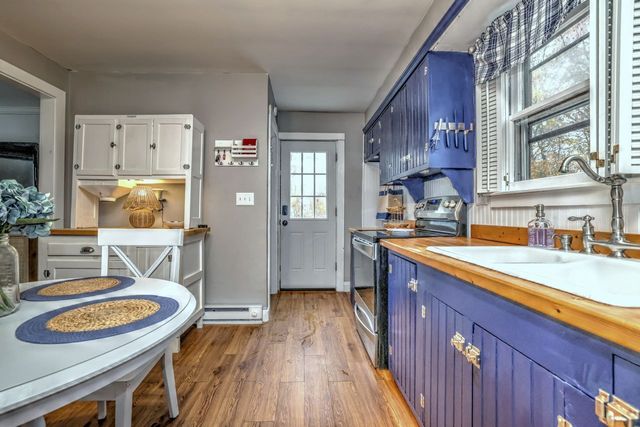 a kitchen with stainless steel appliances granite countertop wooden floors wooden cabinets and sink