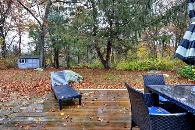 a view of a patio with table and chairs with wooden floor and fence