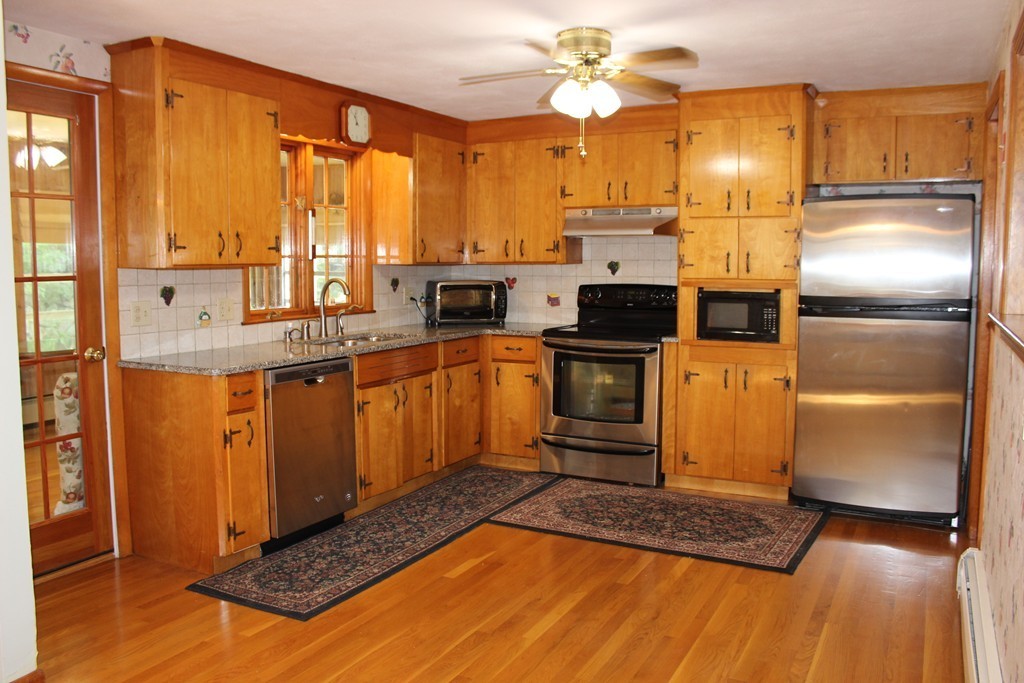 2 Ridge Road Hudson, MA 01749 - Photo 7 of 25 a kitchen with stainless steel appliances granite countertop a sink a stove cabinets and wooden floor