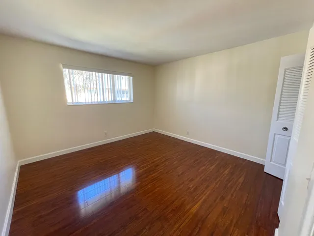 a view of an empty room with wooden floor
