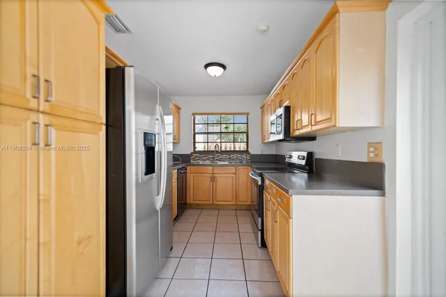 a kitchen with stainless steel appliances granite countertop a refrigerator and a stove top oven