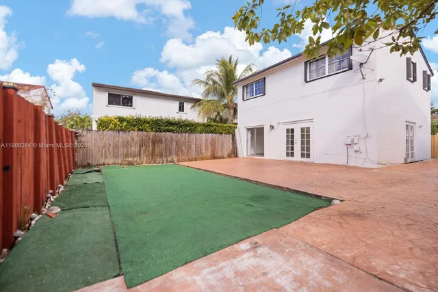 a view of a house with backyard and a tree