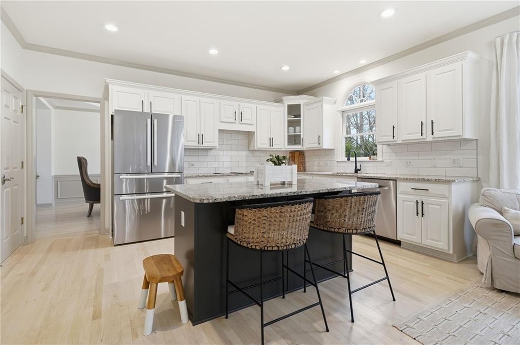 207 Cedarhurst Drive Canton, GA 30115 - Photo 16 of 83 a kitchen with stainless steel appliances granite countertop a table chairs sink and cabinets