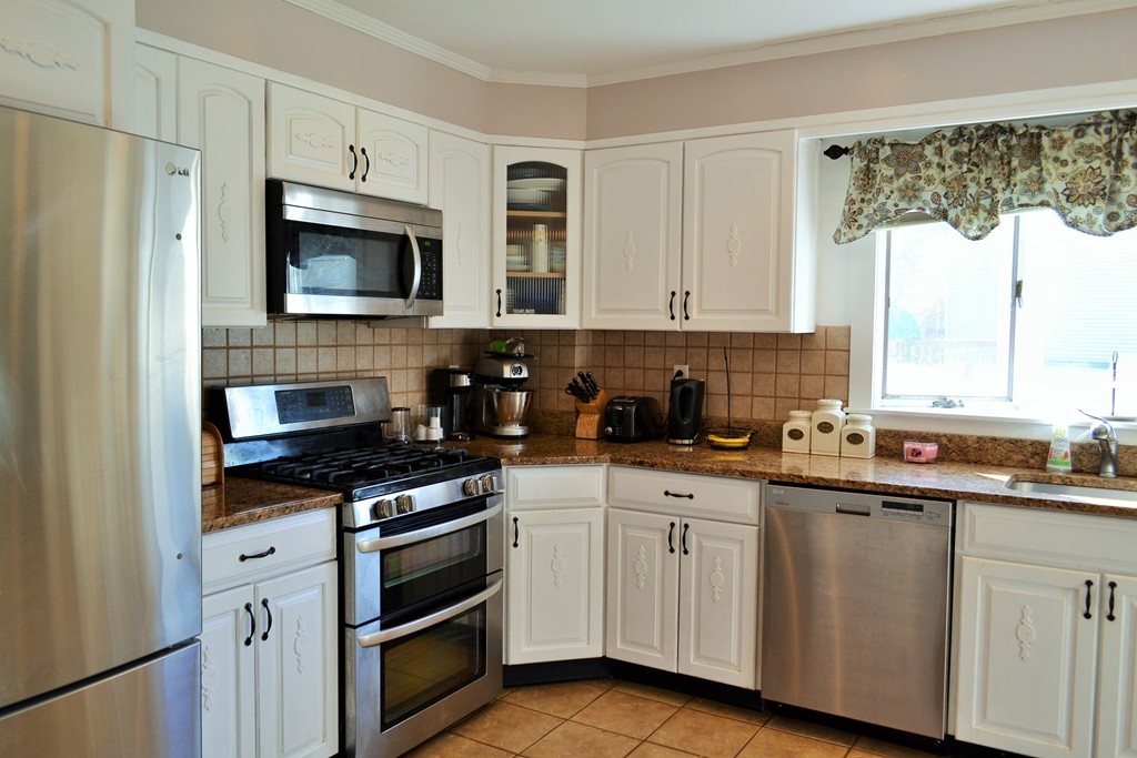 29 Station Road Salem, MA 01970 - Photo 9 of 24 a kitchen with stainless steel appliances a stove sink microwave and cabinets