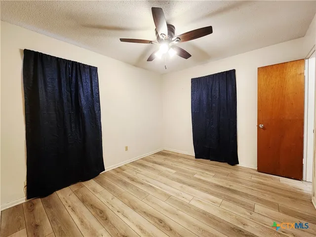 a bedroom with a bed and a ceiling fan