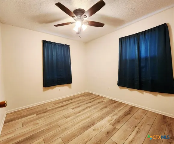 a view of an empty room with a ceiling fan
