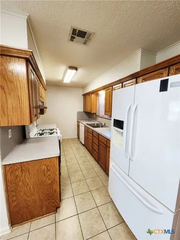 a kitchen with stainless steel appliances a stove a sink and a refrigerator